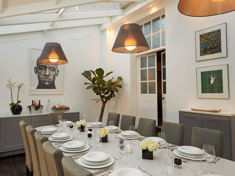 The Orangery dining table set for twelve beneath glass roof panels